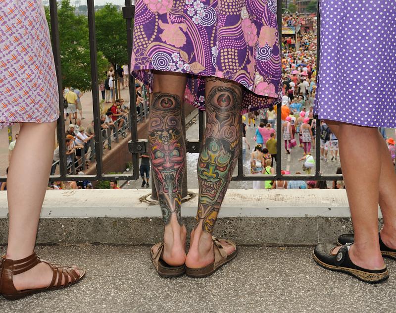 738_0088 Tätowierte Beine schauen aus einem violetten buntgemusterten Nylonkittel heraus. | Schlagermove Hamburg - Ein Festival der Liebe.